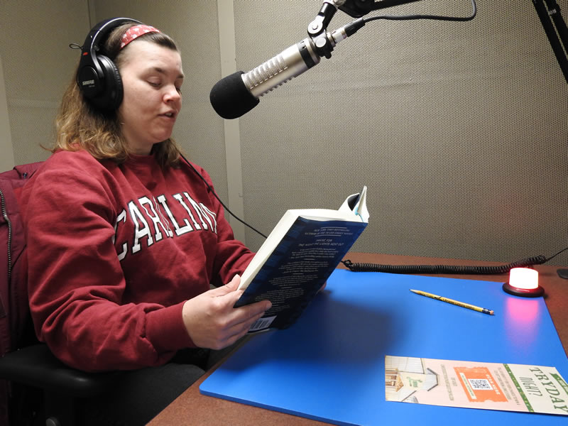 Young woman reading a book in the recording studio.