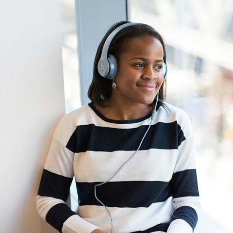 Girl listening to book on headphone. Photo by Christina Morillo.