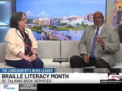 Jennifer Falvey, Talking Book Services Director, sits on the left in Live 5 Charleston's studio with reporter Raphael James on the left.